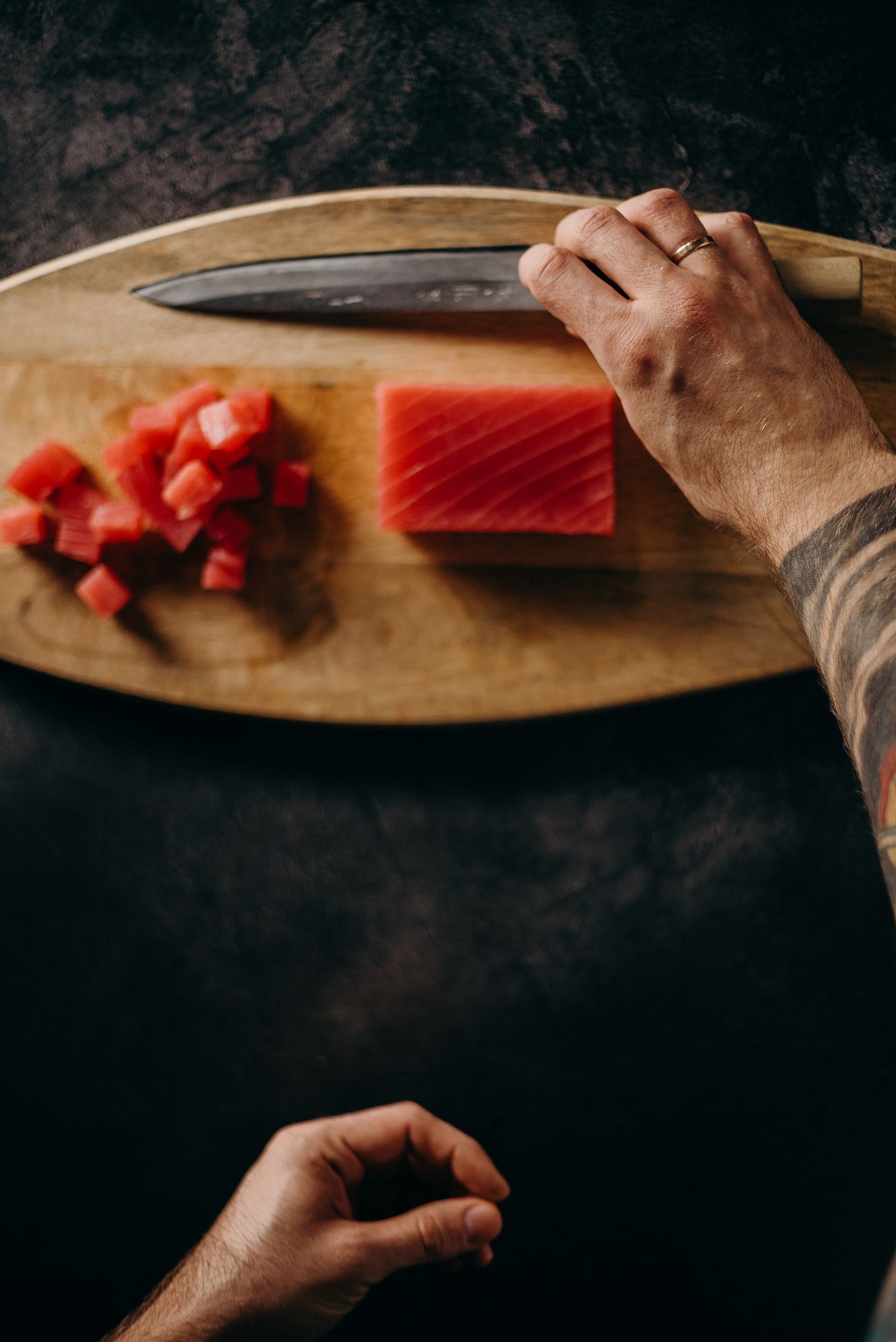 Chef hands precisely slicing fresh tuna