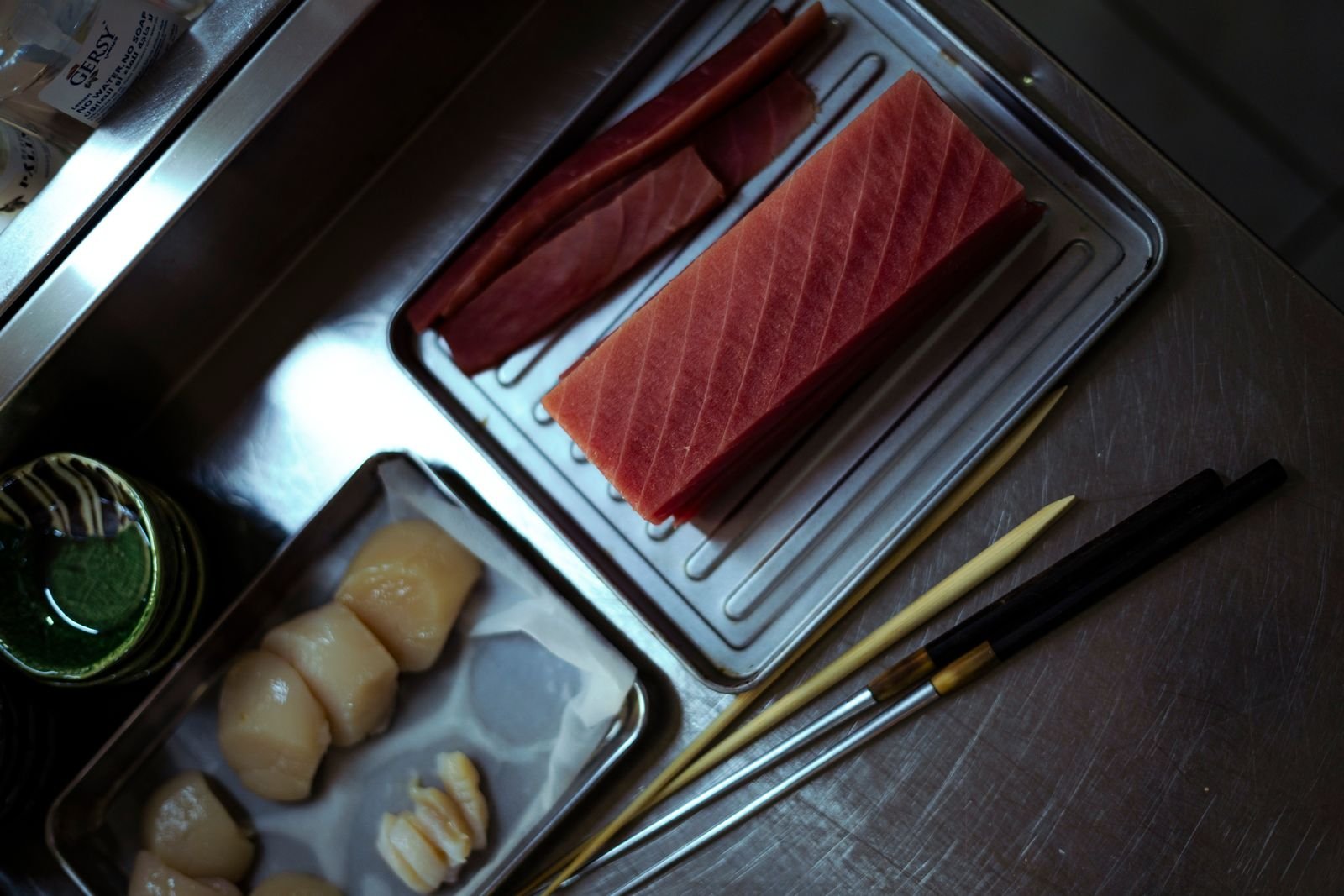 Fresh tuna and scallops arranged at a preparation station